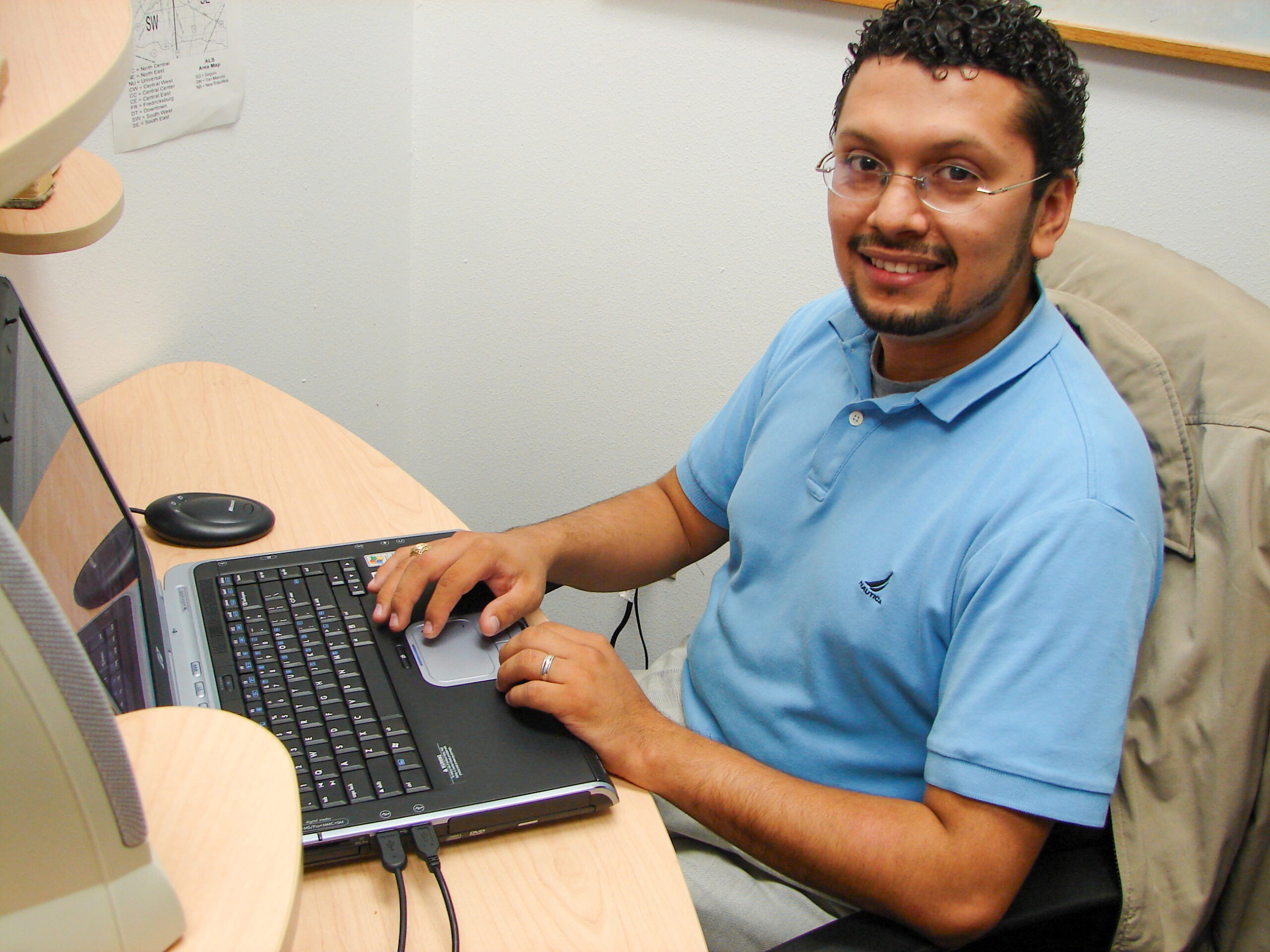 Brenda Oblitas next to VND's first shared hosting server rack, 2006